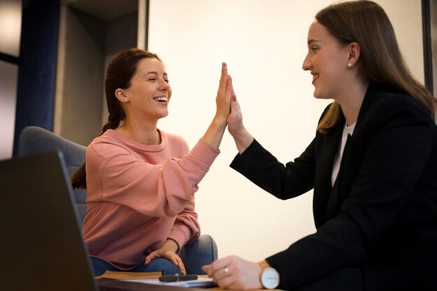 side view smiley women high five