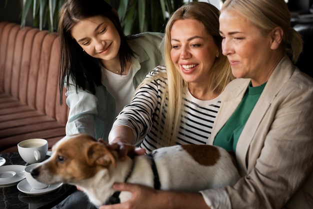 Donne sorridenti di vista laterale con il cane sveglio