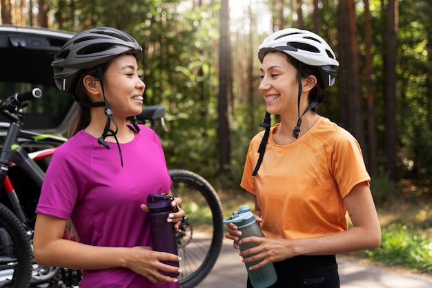 Donne di smiley di vista laterale con i caschi