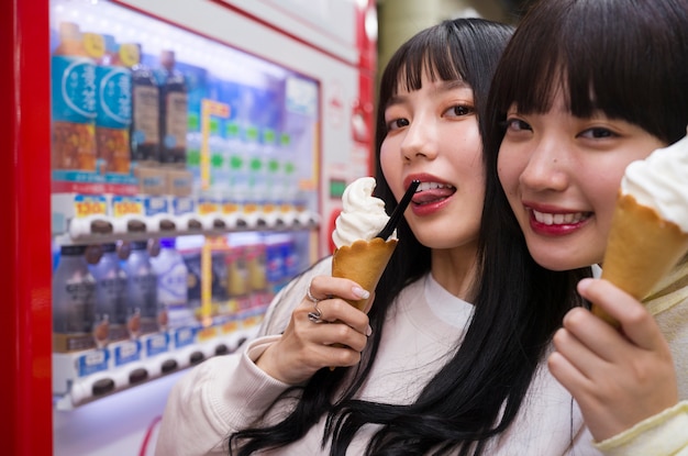 Free photo side view smiley women with ice creams