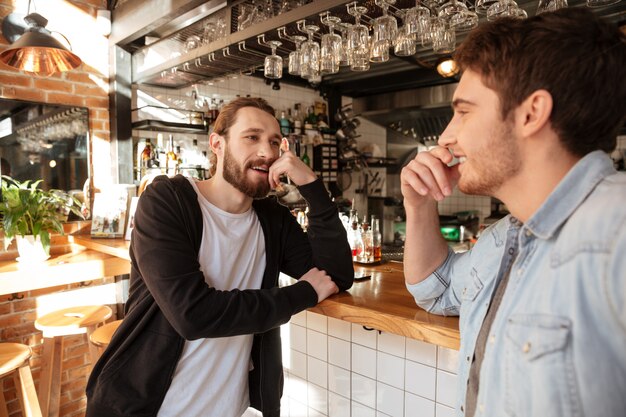 Side view of Smiling Friends standing near the bar