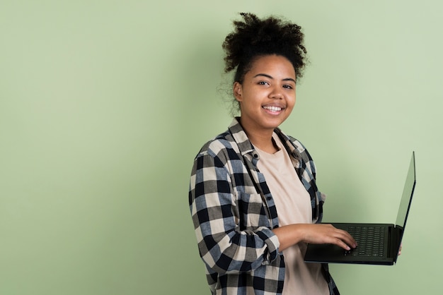 Side view of smiling woman holding laptop