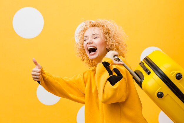 Side view of smiling woman with suitcase