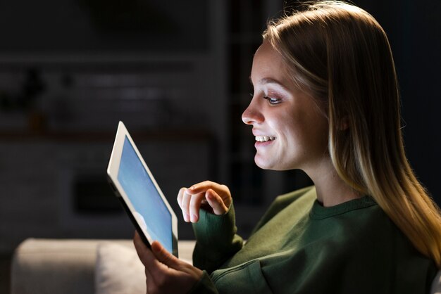 Side view of smiling woman with tablet