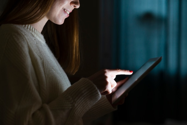 タブレットで笑顔の女性の側面図