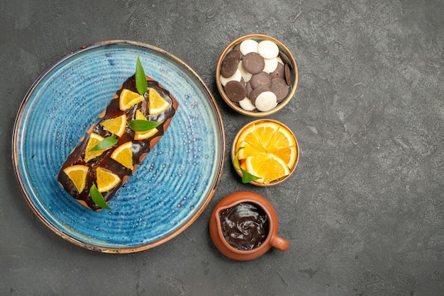 暗いテーブルにレモンとチョコレートで飾られた柔らかいケーキの側面図