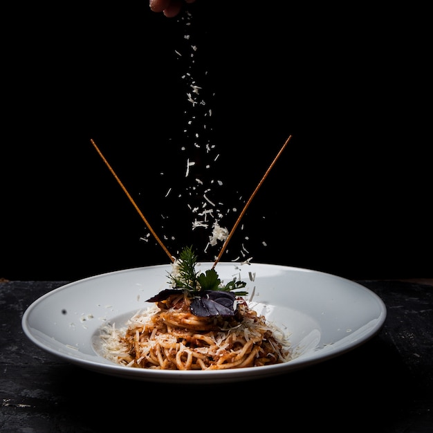 Free photo side view spaghetti with greens and ricotta cheese in round white plate