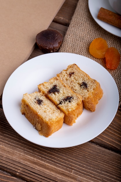 Side view of sponge cake slices with chocolate on a plate