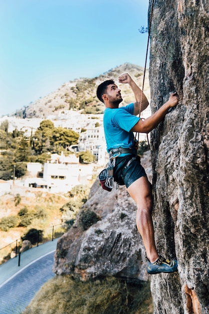 Side view of sporty man climbing
