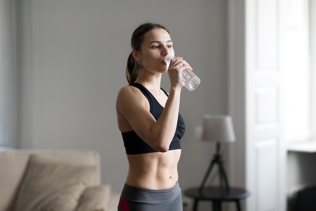 スポーティな女性は、水を飲むの側面図