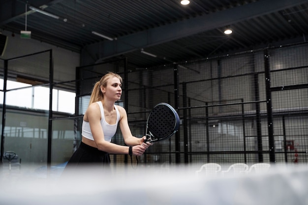 Side view sporty woman playing paddle tennis