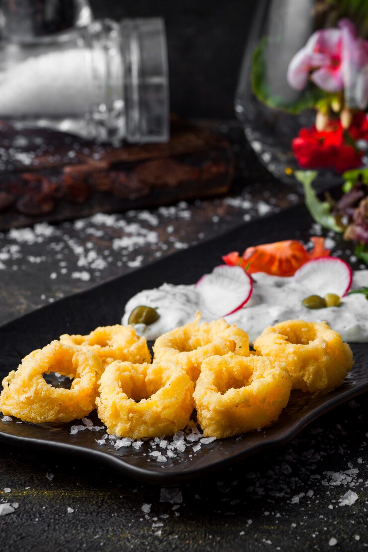 Free Photo side view squid rings in batter with sauce and fresh vegetable salad in tray