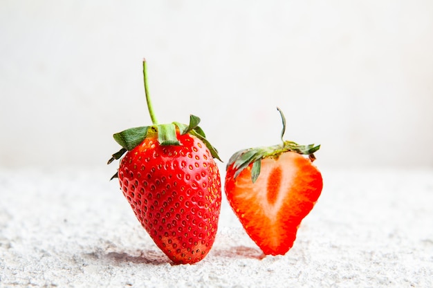 Side view strawberries on white textured background. horizontal