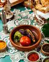 Free photo side view of stuffed vegetables with meat and rice in clay bowl