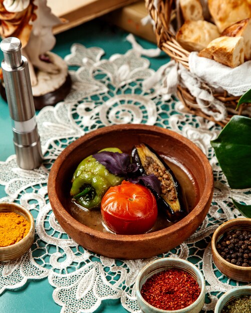 Side view of stuffed vegetables with meat and rice in clay bowl