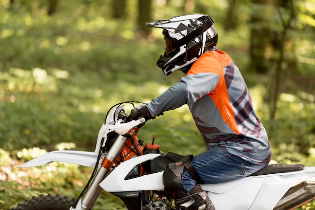 Free photo side view stylish man riding motorbike