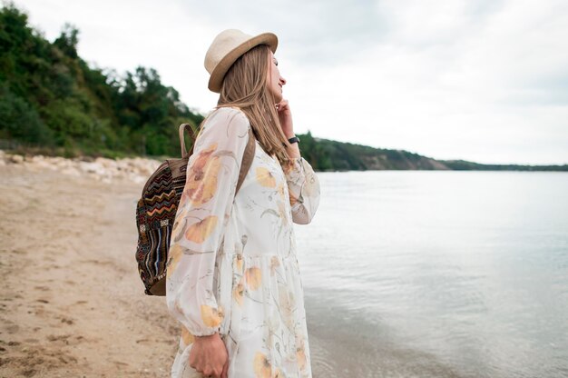 Side view stylish woman with hat enjoying holiday