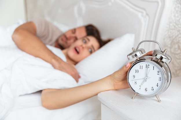 Side view of Surprised couple sleeping together in bed