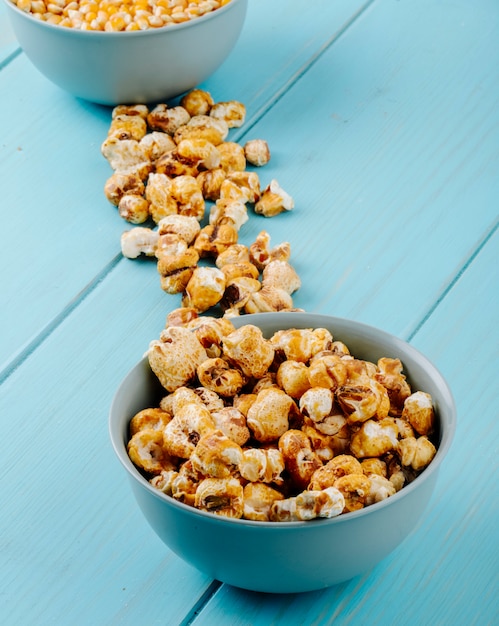 Foto gratuita vista laterale del popcorn al caramello dolce in una ciotola su sfondo blu