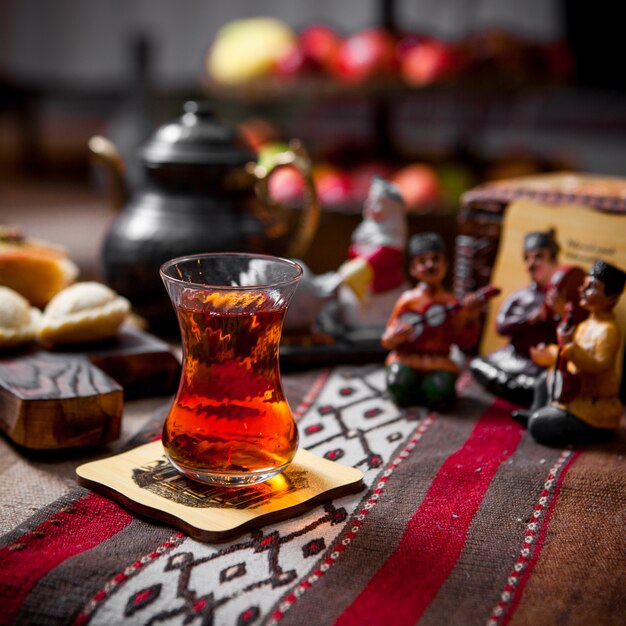 Side view tea table with glass of tea and figurines and teapot in table on restaurant