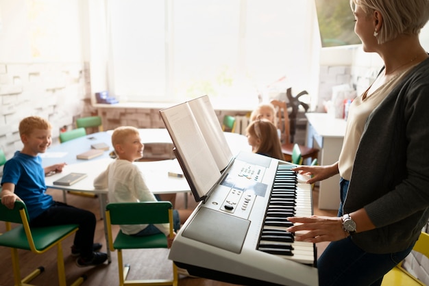 Insegnante di vista laterale che suona il pianoforte