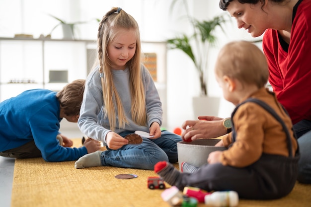 Insegnante di vista laterale che guarda i bambini che giocano