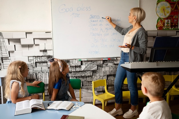 Free photo side view teacher writing on whiteboard