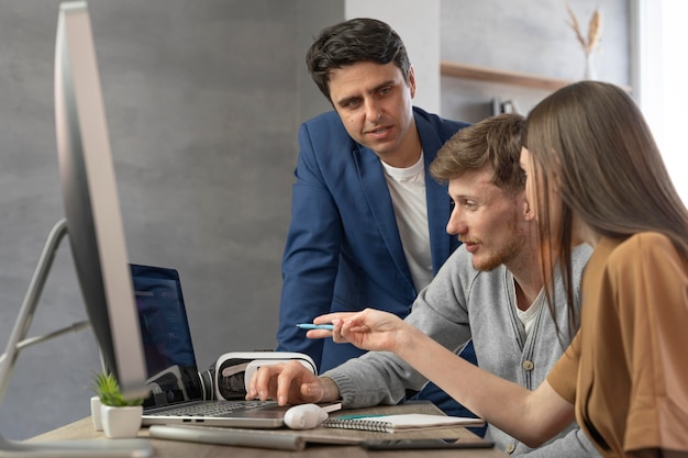 Side view of team of professionals working with new technology on computer and laptop