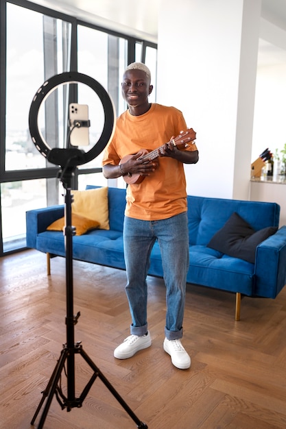 Free photo side view teen playing the ukulele