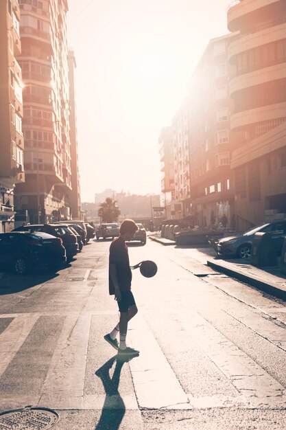 Side view of teenage boy playing basketball