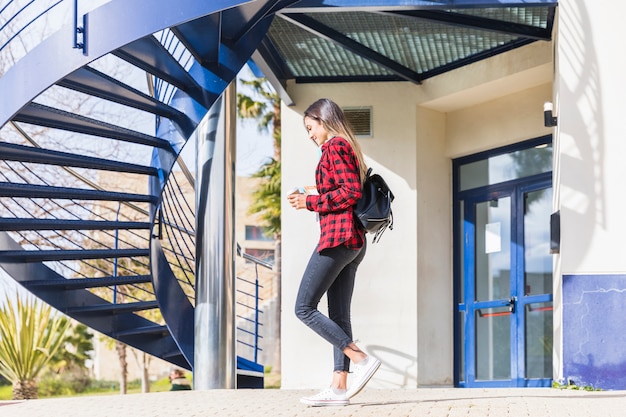 Side view of a teenage female student walking in front of university building