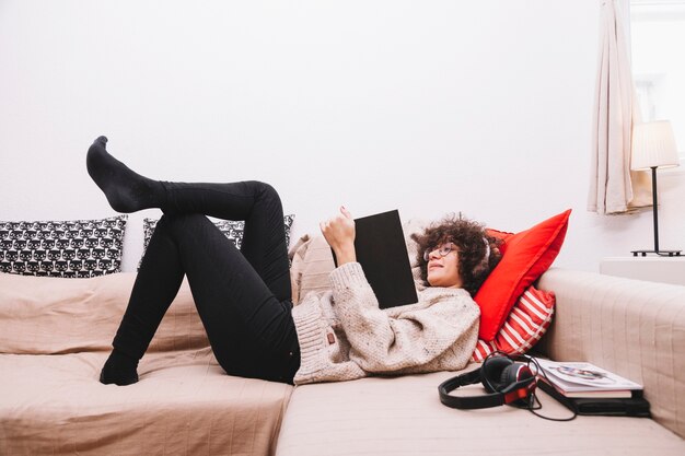 Side view teenager reading on sofa