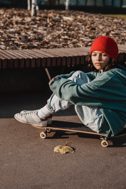 Side view of teenager with skateboard outside