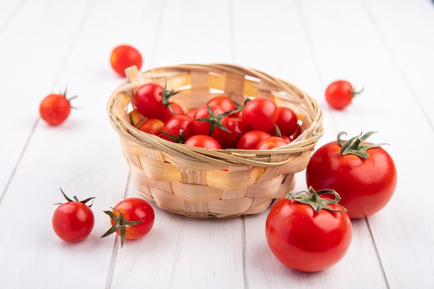 Side view of tomatoes in basket and on wood