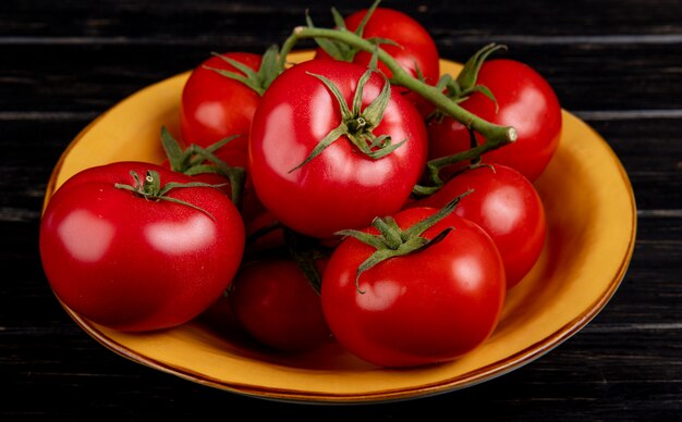 Side view of tomatoes in bowl on wooden table