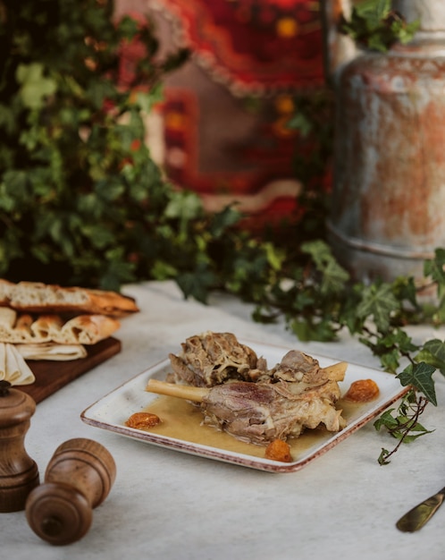 Side view of traditional azerbaijani buglama decorated with dried fruits on a white plate