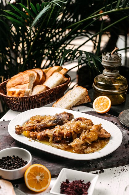 Side view of traditional azerbaijani buglama on a white plate with onions