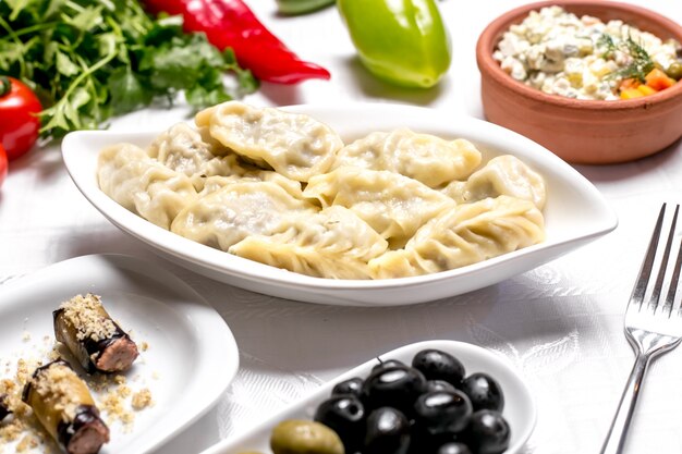 Вид сбоку на традиционное азербайджанское блюдо гюрза с оливками и зеленью