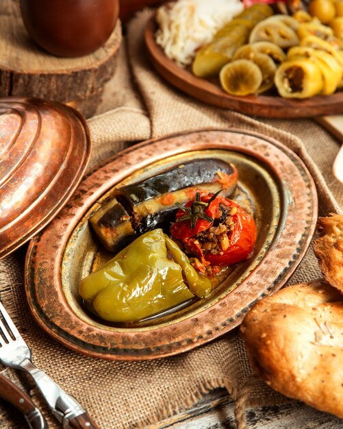 Вид сбоку на традиционное азербайджанское блюдо мясная долма из овощей перец болгарский помидор и баклажан