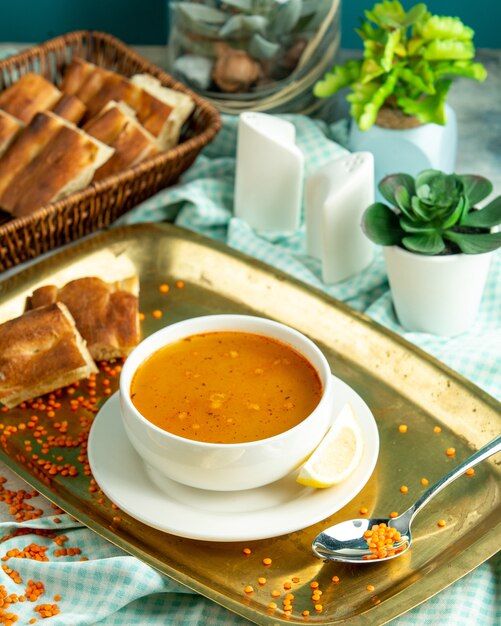 Side view traditional azerbaijani lentil soup with tandoor bread on a tray