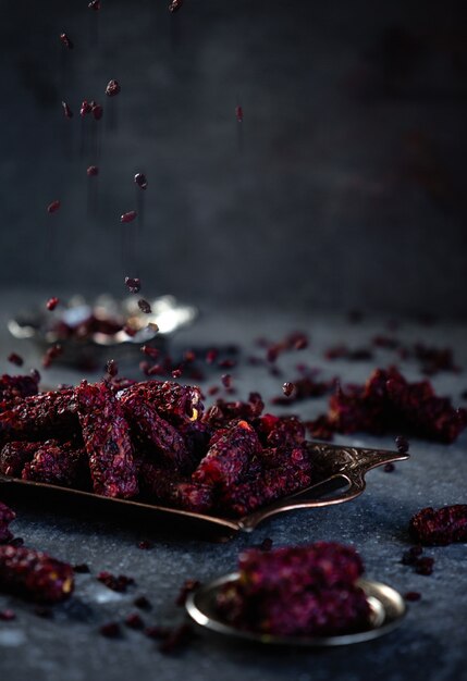 Side view of traditional turkish delight barberry lokum on antique tray on black wall