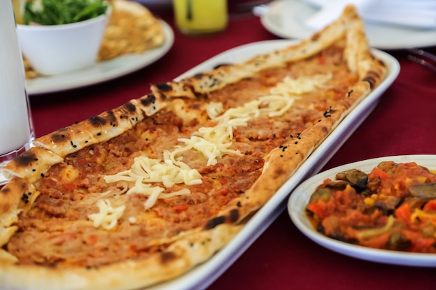 Side view traditional turkish dish meat pide with cheese