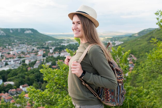 Free photo side view traveller with hat enjoying the view