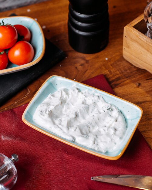 Side view of turkish sauce cacik with herbs on a wooden table