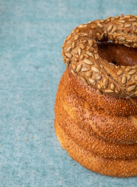 Side view of turkish sesame breads on right side and blue background with copy space