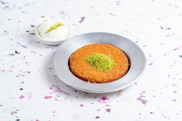 Side view of turkish traditional dessert kunefe served with ice cream on the table