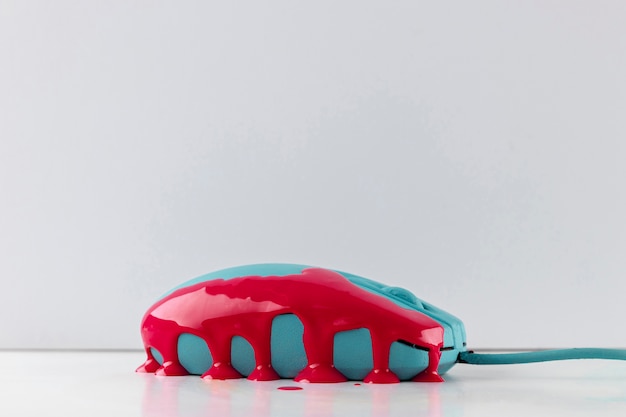 Side view of turquoise mouse with dripping paint