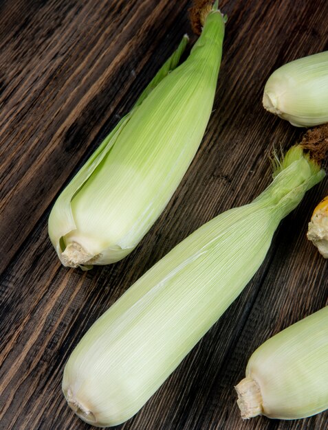 Side view of uncooked corns on wooden table