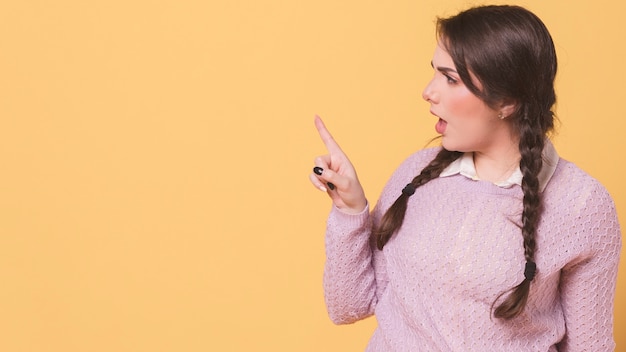 Vista laterale della donna arrabbiata che indica dito