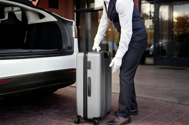 Free photo side view valet holding baggage